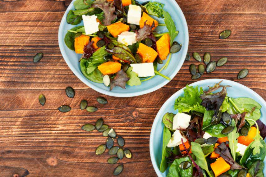 Ajout de graines de courge sur une salade